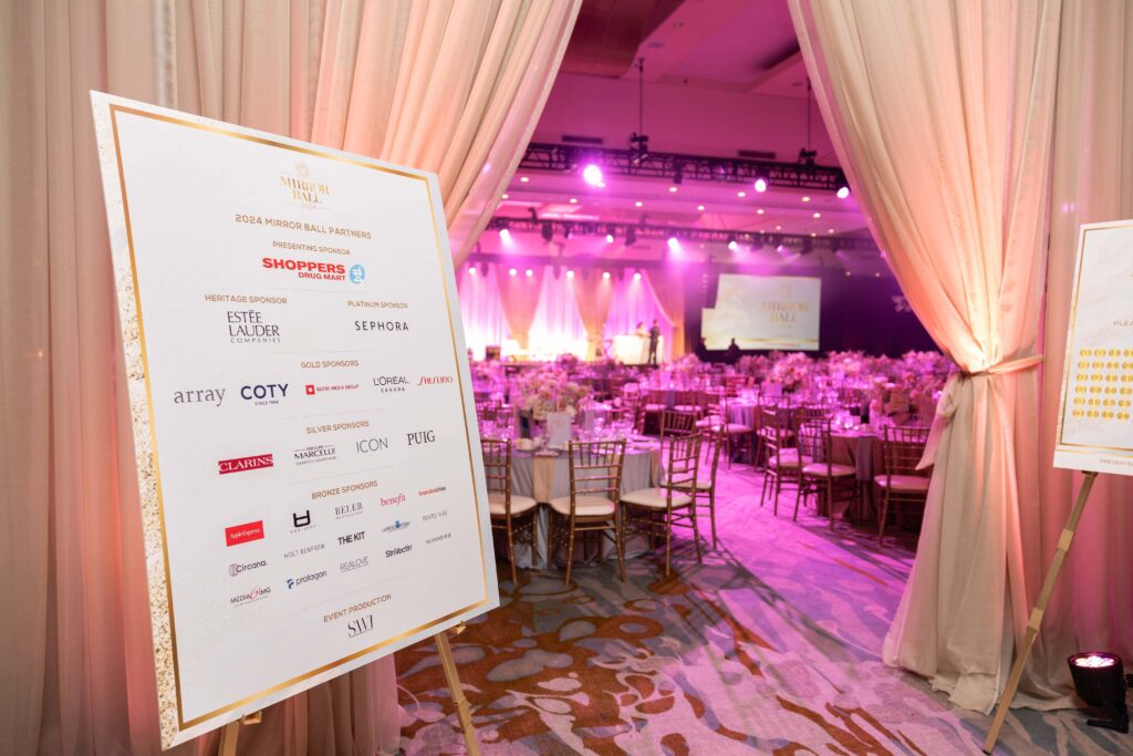 Ballroom set for 2024 Mirror Ball with sponsor board listing Shoppers Drug Mart, Estée Lauder, Sephora, and more.