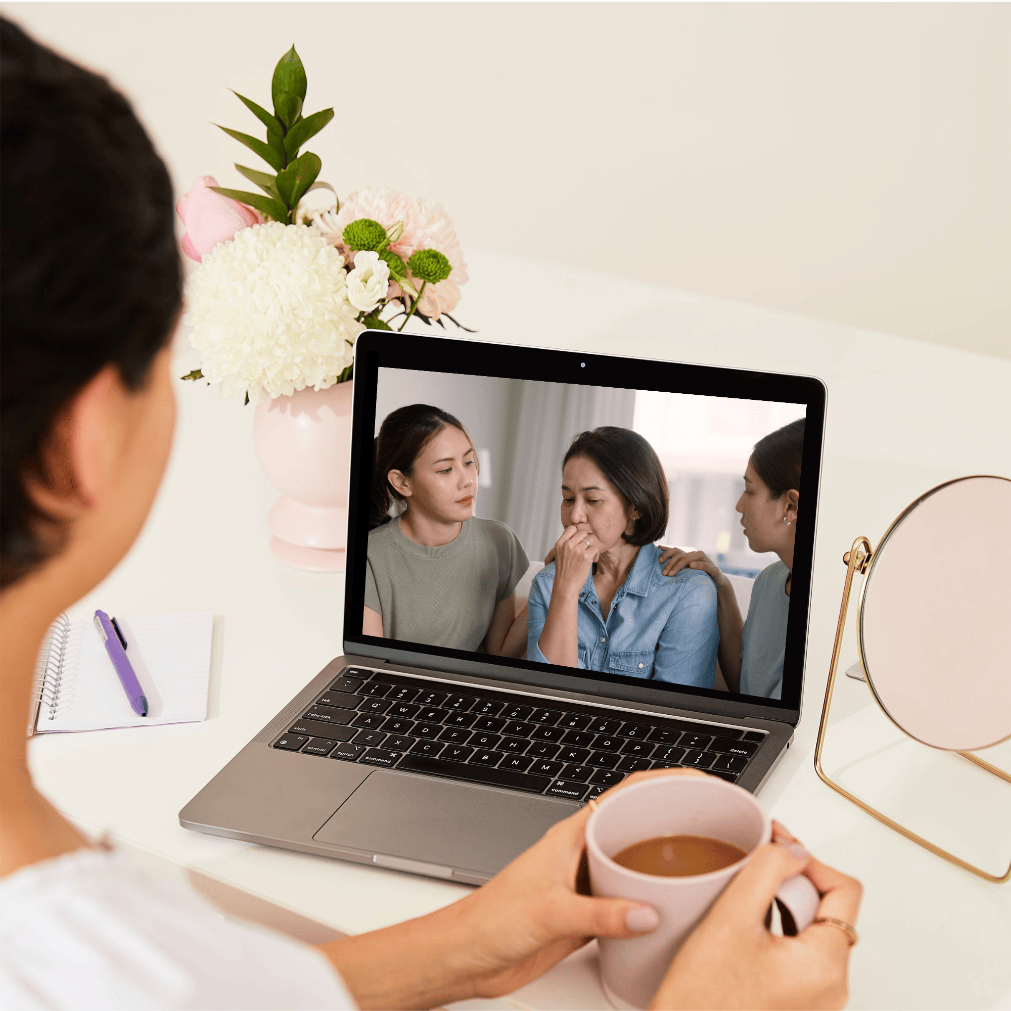 Over-the-shoulder view of a woman at a desk looking at a talking to kids workshop on a laptop.