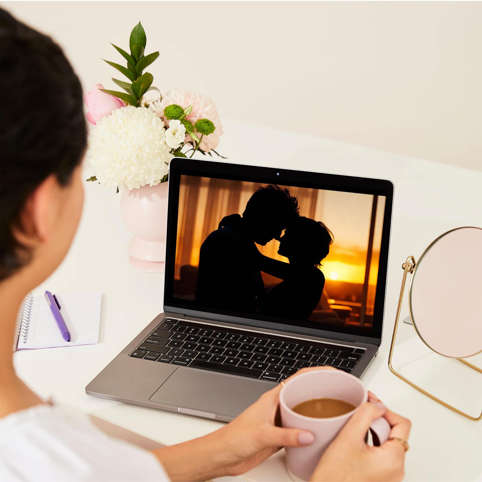 On overhead shot of a woman watching an online Sexual Wellbeing workshop on her laptop.